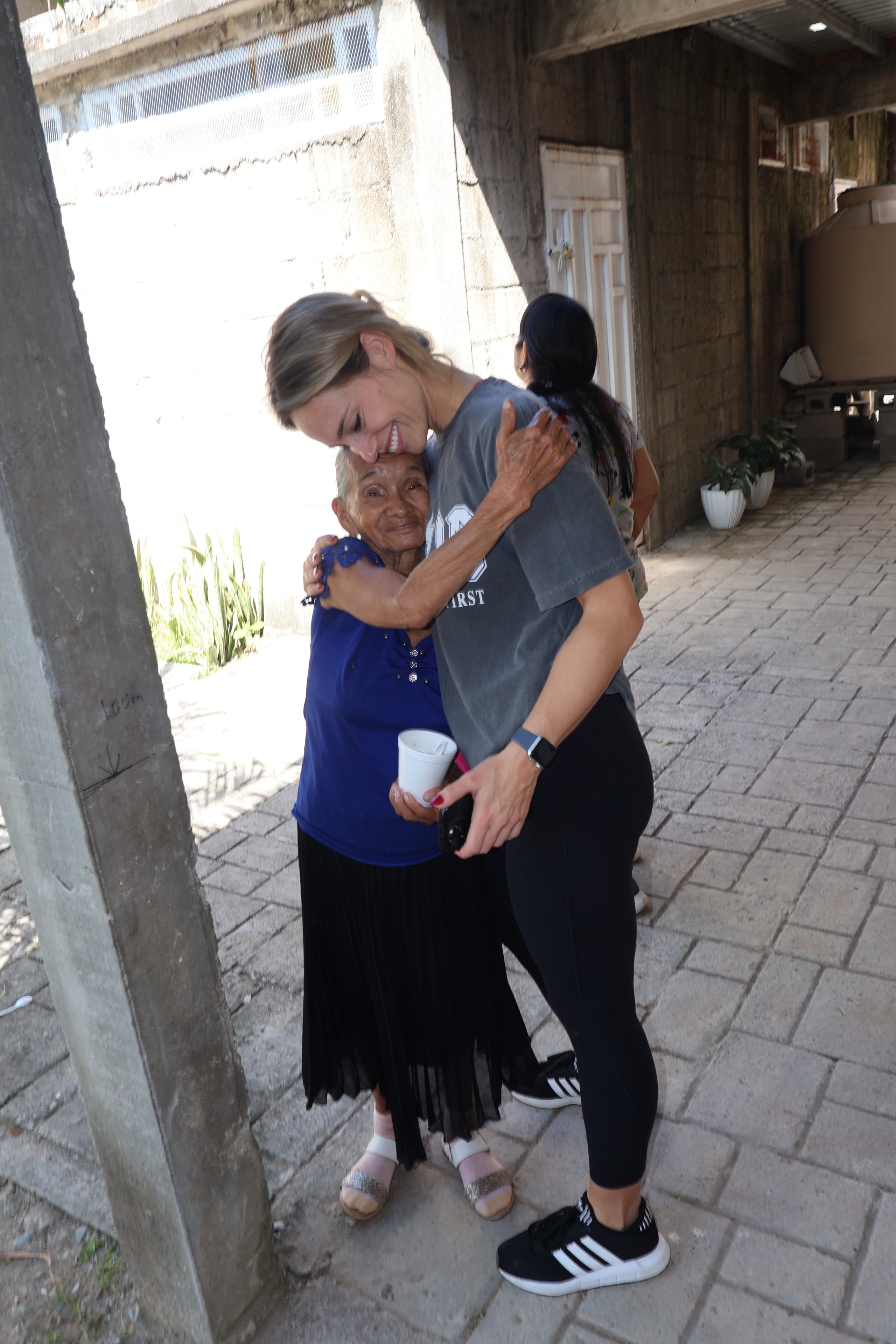 Young woman hugging an elderly woman outdoors