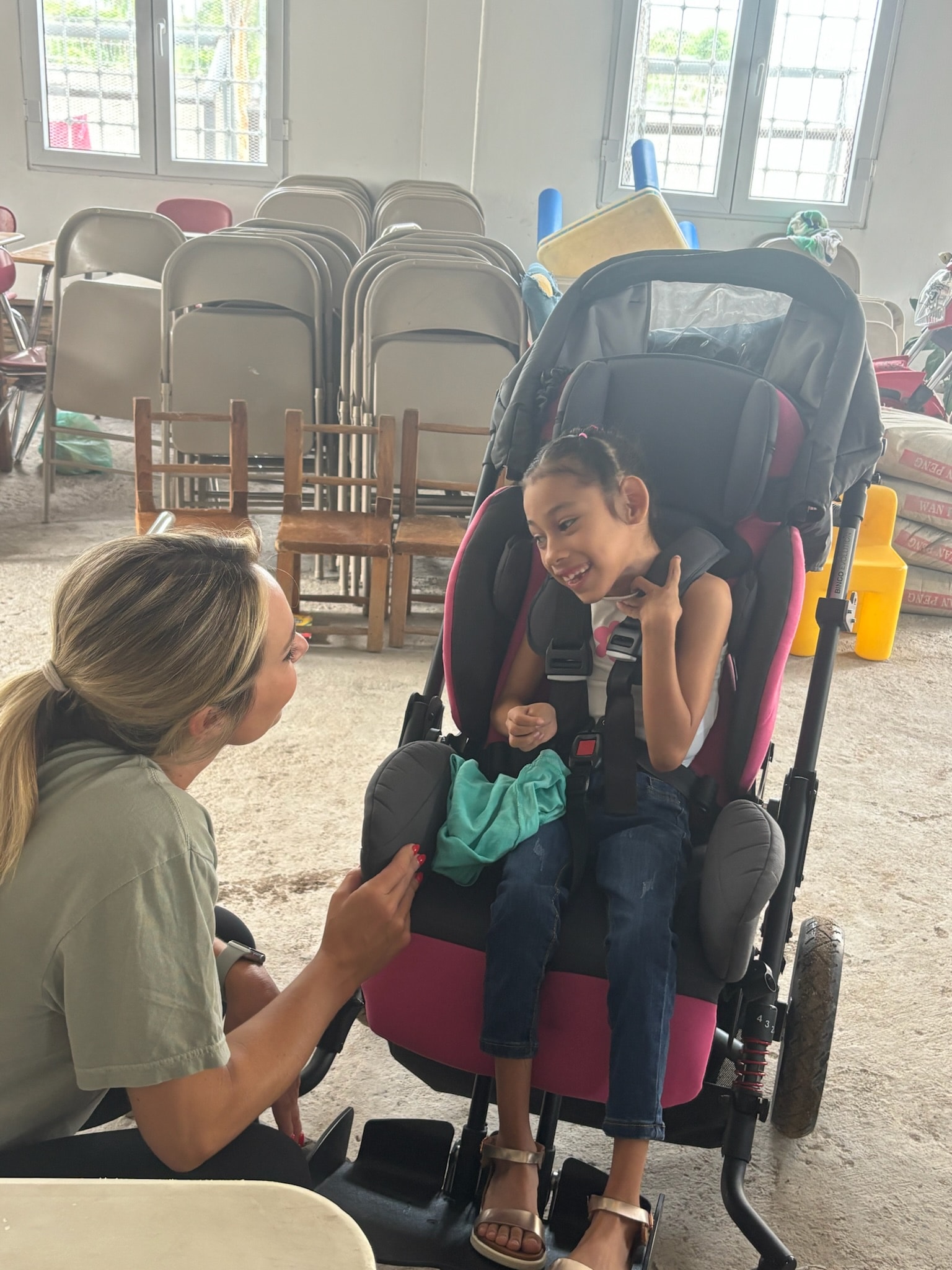 Woman talking to a child in a stroller indoors
