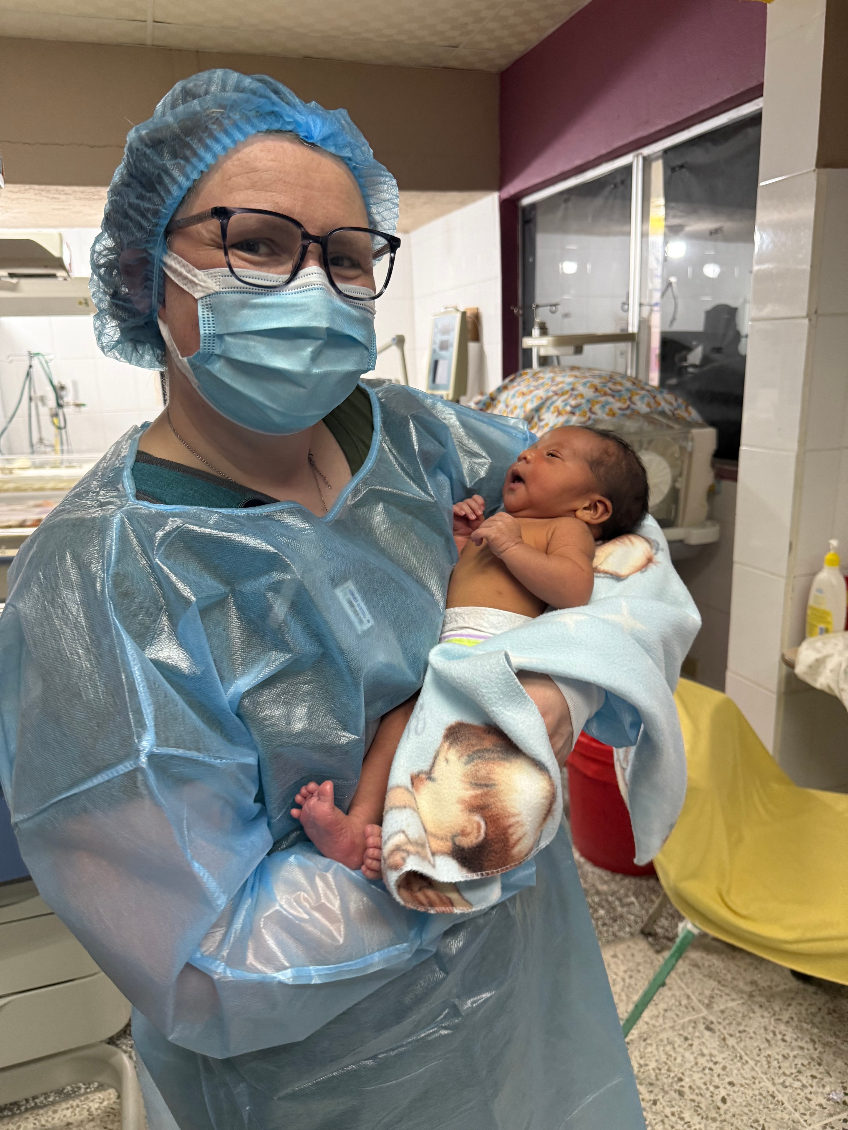 Mother and healthcare worker holding a newborn baby