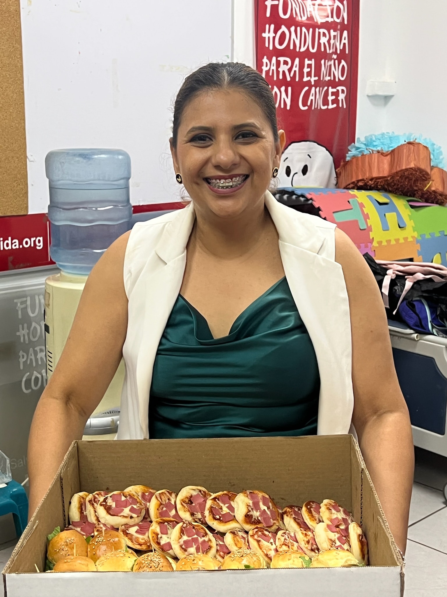 Woman holding a box of baked goods, smiling