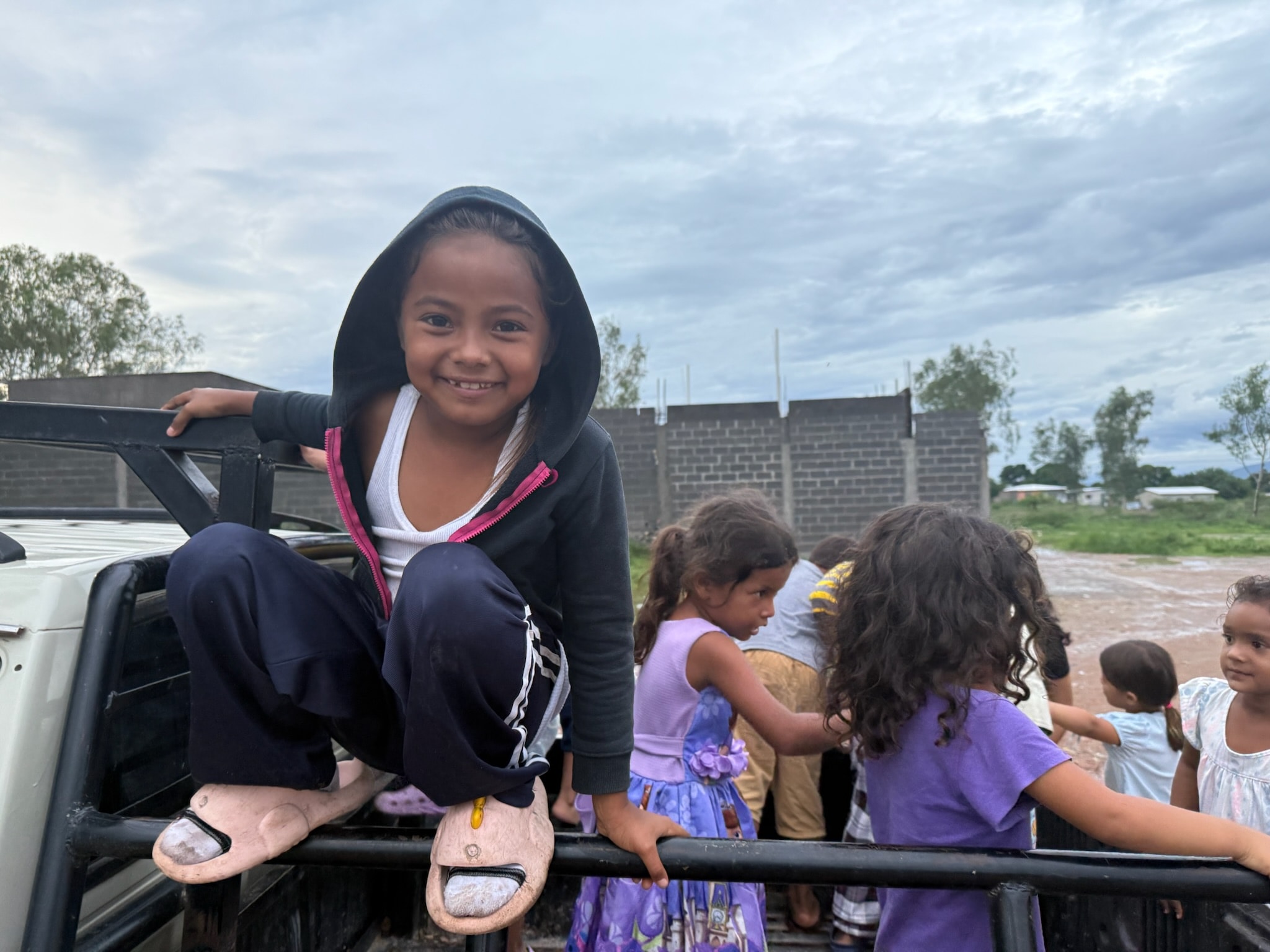 Girl smiling in a truck bed with children