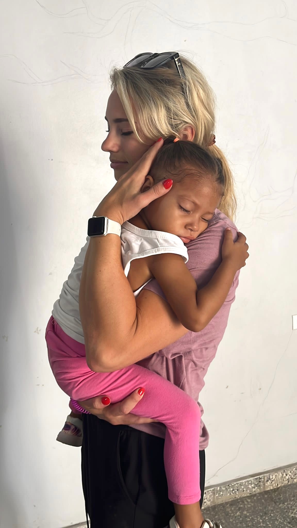 A mother holding her young daughter close